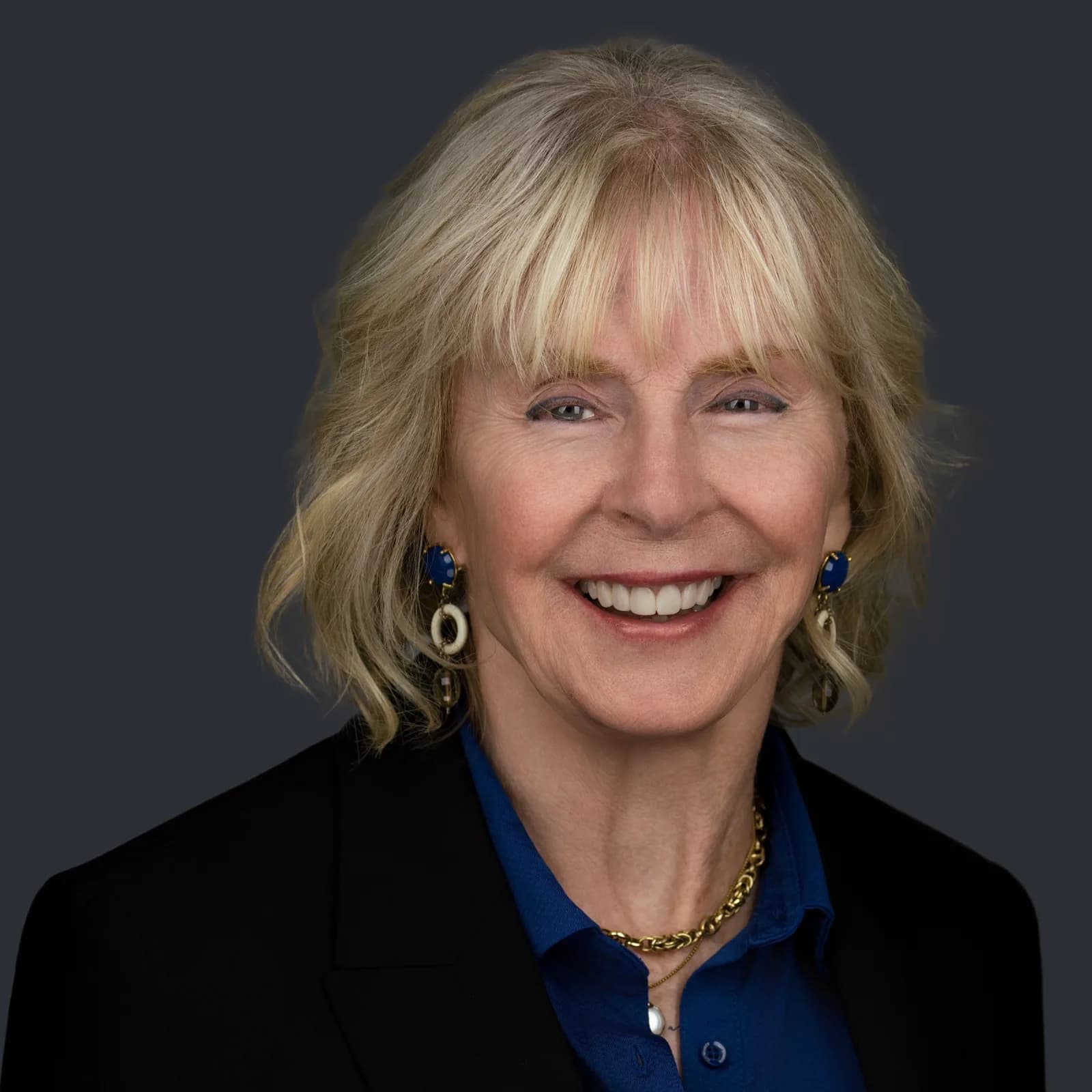 Dana Weber, smiling in a black blazer over a blue shirt