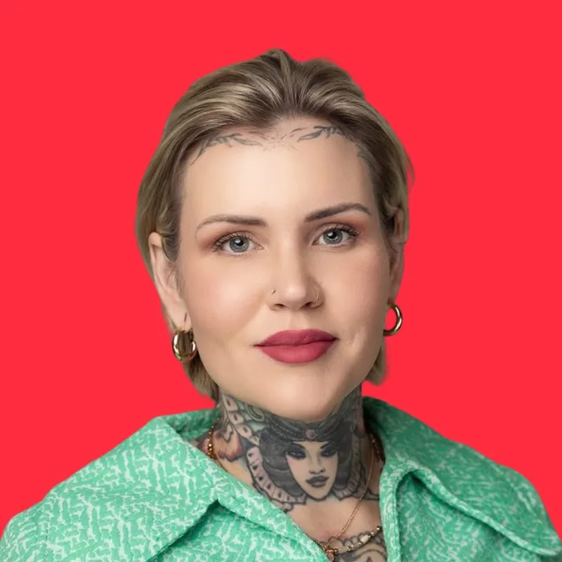 Tarra Quinn in a green shirt against a bright red background