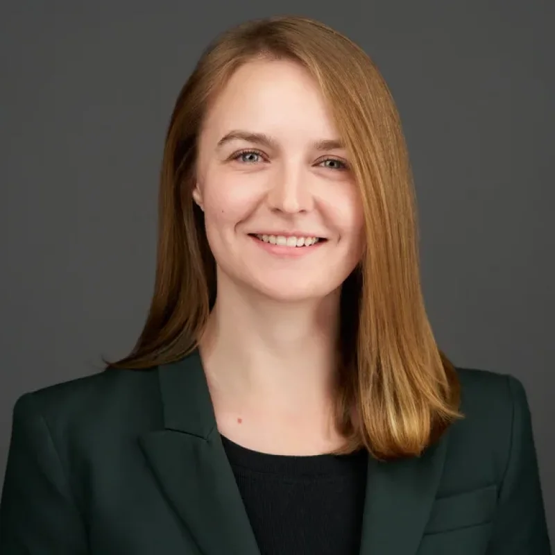 Jess Meloy, smiling in a dark green blazer